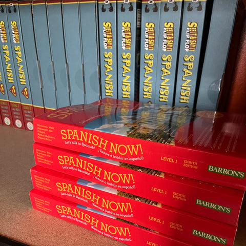 A set of 'Spanish Now' textbooks with red and blue covers, displayed in a stack.